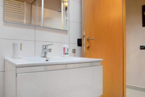 a bathroom sink with a bottle of soap on it at Il sole di calde Lago Maggiore 505 in Castelveccana