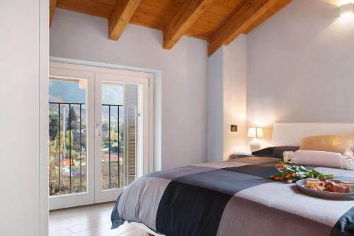 a bedroom with a large bed and a large window at Il sole di calde Lago Maggiore 505 in Castelveccana