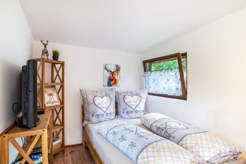 a room with a couch with pillows and a tv at Haus am Bach in Schönmünzach
