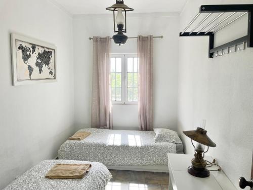 a bedroom with two beds and a window at Casa Castelão in Palmela