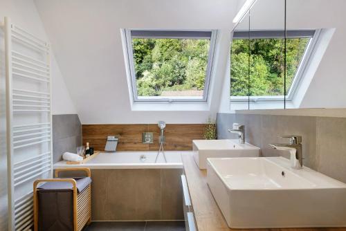 a bathroom with two sinks and two windows at Haus Schiltach in Schramberg