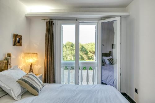 ein Schlafzimmer mit einem Bett und einem großen Fenster in der Unterkunft Mareva in Begur
