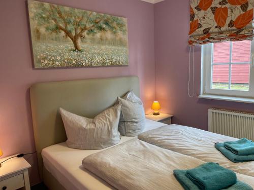 a bedroom with a bed with a painting on the wall at Ferienhaus Pirol in Zossen