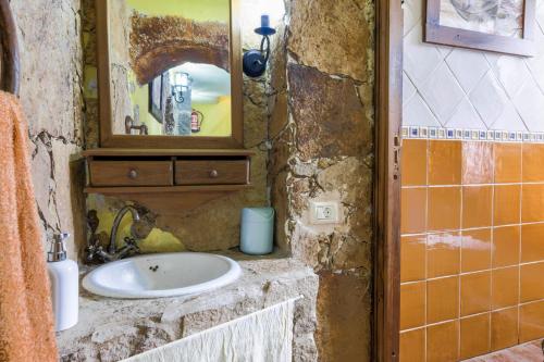 a stone bathroom with a sink and a mirror at Casa Carmela in La Guancha