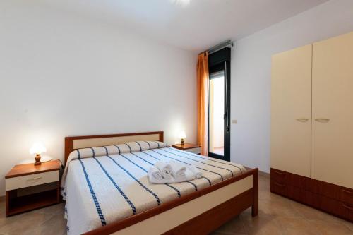 a bedroom with a bed with two towels at Appartamenti Cavour H in Villasimius