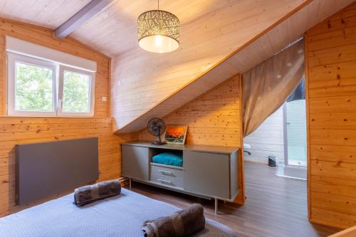 a living room with a tv in a wooden house at Villa À Isturits Avec Piscine in Isturits
