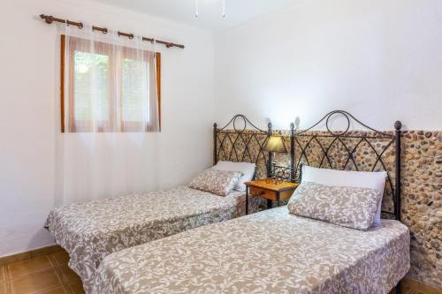 a bedroom with two beds and a window at Can Sito in Cala Tuent