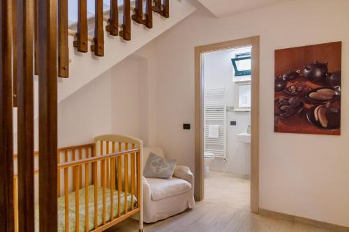 a baby room with a crib and a staircase at Villa Glicine - Colleberto in Follonica