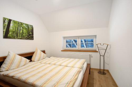 a bed in a room with a window at Ferienwohnungen Übern Hof in Schmallenberg