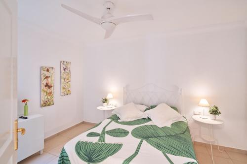 a white bedroom with a bed and two tables at Terrazas del Duque Beach Apartment in Adeje