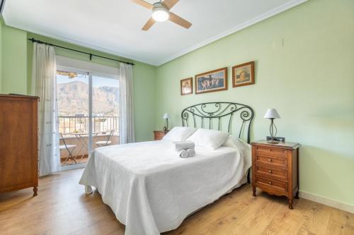 a bedroom with a white bed and a window at La Gimena in Orihuela