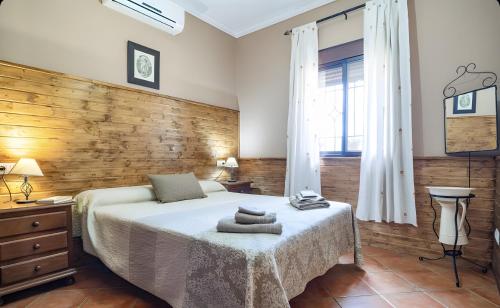 a bedroom with a bed and a wooden wall at La Cañada in El Gastor