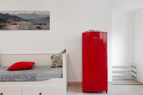 a red refrigerator next to a bed in a room at La piccola Lami in Intra