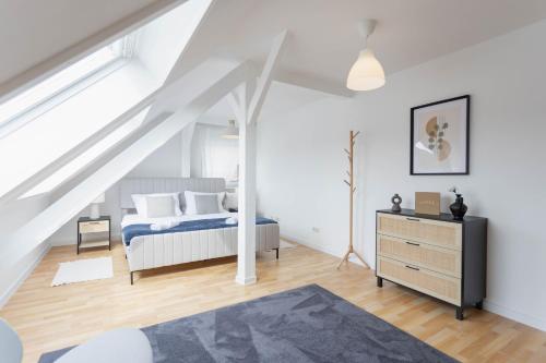 a white attic bedroom with a bed and a dresser at Cityloft für Stilvolle in Dessau