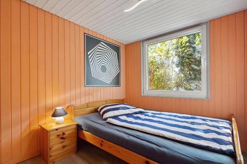 a bedroom with orange walls and a bed with a window at Ferienhaus 219 in Zadelsdorf
