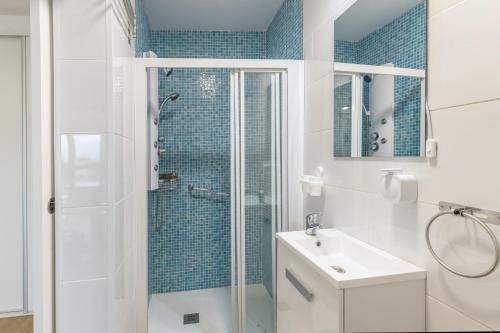 a white bathroom with a shower and a sink at Casa Lea Artenara in Artenara