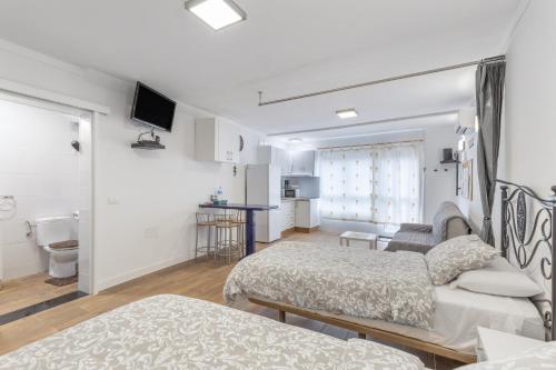 a hotel room with two beds and a bathroom at Casa Lea Artenara in Artenara