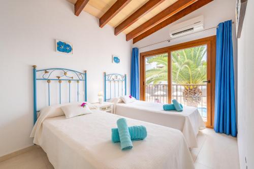 two beds in a room with a window at Apartamento Poseidonia in Felanitx