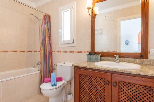 a bathroom with a toilet and a sink and a mirror at Apartamento Poseidonia in Felanitx