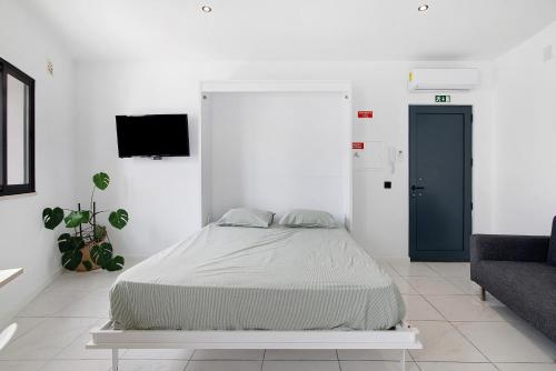 a white bedroom with a bed and a couch at Mi Casa Es Su Casa Nº4 in Albufeira