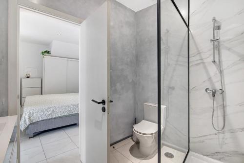 a bathroom with a shower and a toilet and a bed at Mi Casa Es Su Casa Nº4 in Albufeira