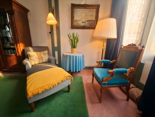 a bedroom with a bed and two chairs and a table at Huize Beukenstein in Lochem