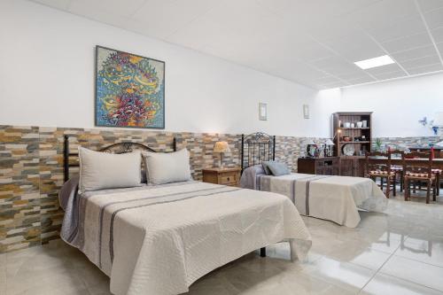 a bedroom with two beds and a dining room at Loft Los Olivos in Algar