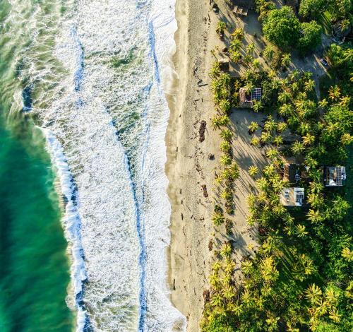 an aerial view of a beach with houses and the ocean at Natyva House in Guachaca