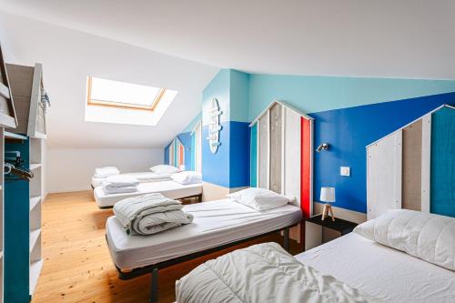 a group of beds in a room with blue walls at Maison Boyardville Piscine in Saint-Georges-dʼOléron