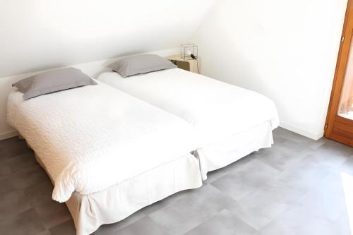 a bedroom with a white bed with white sheets at Gîte La Maison De Caroline, Spa in Sigolsheim