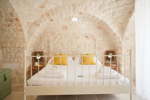 a bedroom with a bed in a stone wall at Trullo Delori with infinity Pool in Villa Castelli