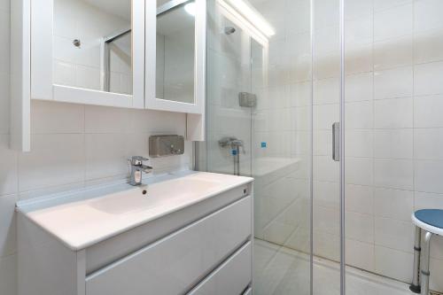 a white bathroom with a sink and a shower at Los Molinos 735 in Maspalomas