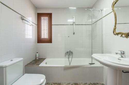 a bathroom with a tub and a toilet and a sink at Apartamentos Villa Martinez in Salobreña