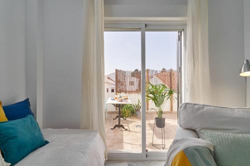 a living room with a bed and a sliding glass door at Casa Sueña in Calahonda