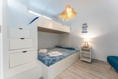 a small bedroom with a bunk bed and a lamp at Seafront Beach house Rocas del Mar in Mijas