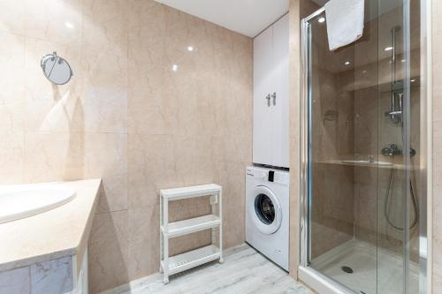 a bathroom with a sink and a washing machine at Seafront Beach house Rocas del Mar in Mijas