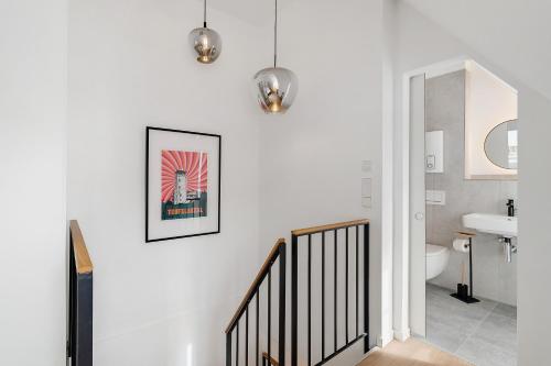 a bathroom with white walls and a staircase with a sink at Altes Forstamt in Gernsbach