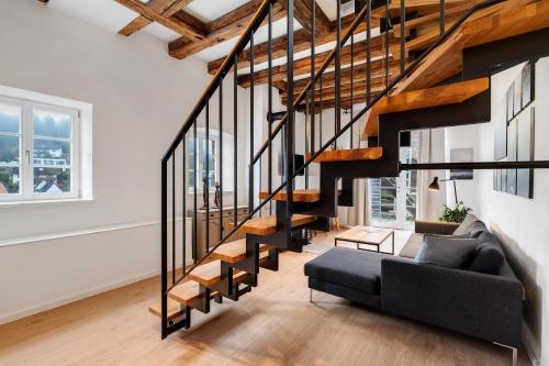a living room with a staircase and a couch at Altes Forstamt in Gernsbach