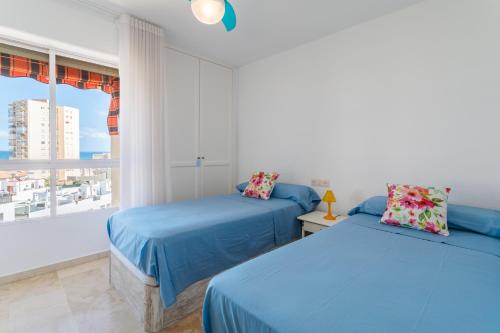 two beds in a room with a window at Torre Mar Muchavista in El Campello
