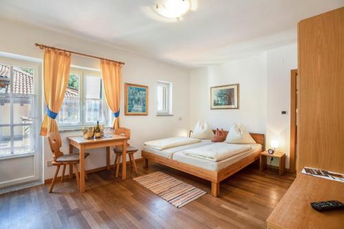 a bedroom with a bed and a desk and a table at Weingut Lieselehof Apt Vitis in Caldaro
