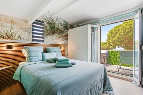 a bedroom with a large bed and a balcony at Un Petit Paradis à Gigaro in La Croix-Valmer