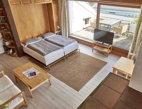a living room with a bed and a large window at Bodenseeblick in Konstanz