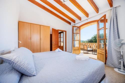 a bedroom with a large bed and a balcony at Son Calletes in Artá