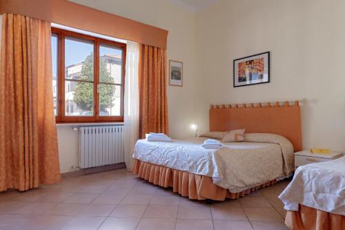 a bedroom with two beds and a window at Bandb Cindy in Navacchio