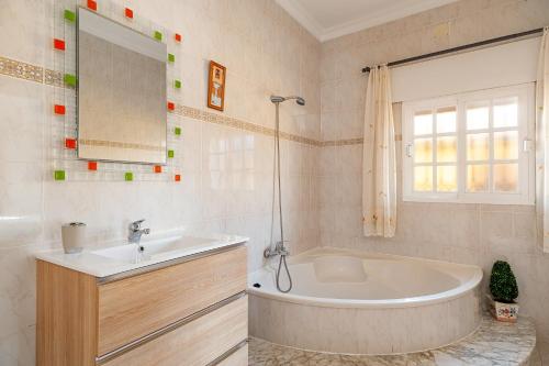 a bathroom with a tub and a sink at Casa Chiqui - solo familias in Conil de la Frontera