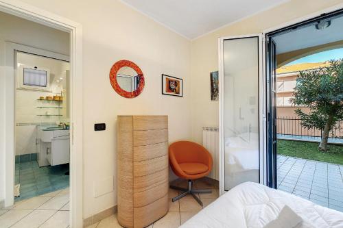 a bedroom with a bed and a chair and a bathroom at La Casa Di Freddy - Loano in Loano