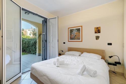 a bedroom with a white bed and a glass door at La Casa Di Freddy - Loano in Loano