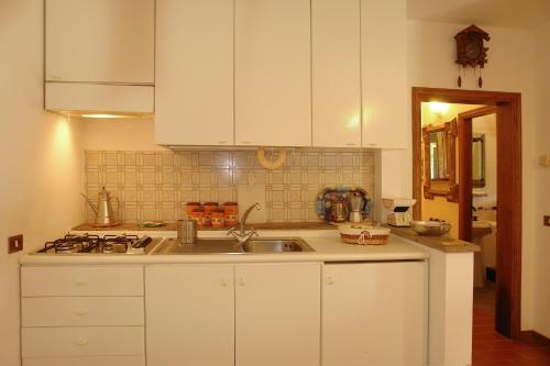 a kitchen with white cabinets and a sink at La Cerretola in Città della Pieve