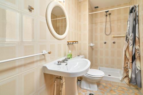 a bathroom with a sink and a toilet and a mirror at Lily in Almuñécar