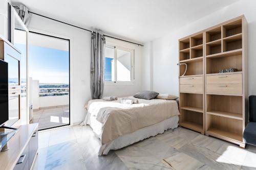 a bedroom with a bed and a large window at Studio Vista Bonita in Sitio de Calahonda